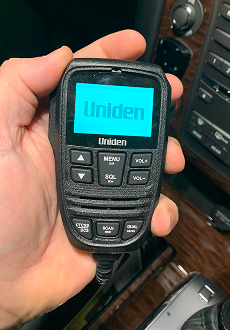 Uniden X76 controller microphone held in hand in a vehicle Australia