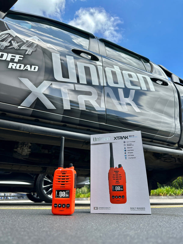 Uniden XTRAK 50-O orange handheld UHF CB radio with retail pack outdoors by a 4WD Australia