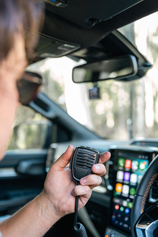 Uniden X75 controller microphone held in hand in a vehicle Australia